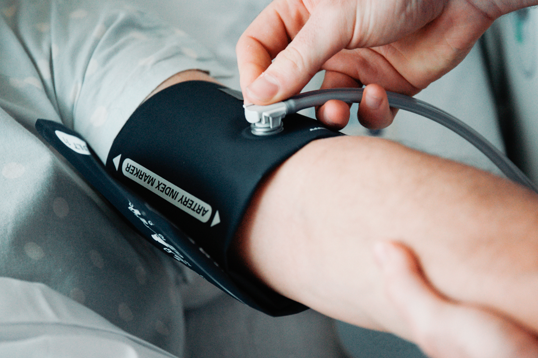 Clinician positioning blood pressure cuff.